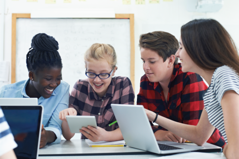 teens read from a tablet together