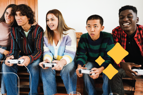 Five teens sit together playing video games