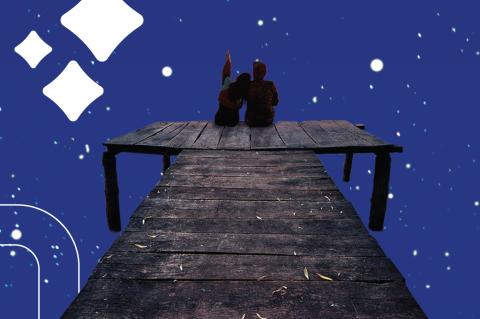 two people sit at the end of a dock and one points to the night sky