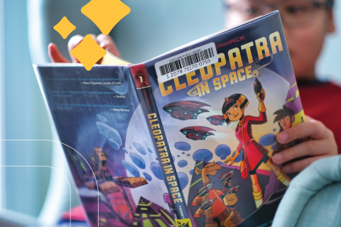 boy reads a graphic novel in the library